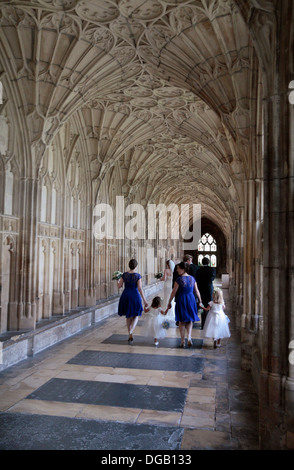 Bridal group passing through the Cloisters in Gloucester Cathedral, Gloucester, Glous, UK. Stock Photo