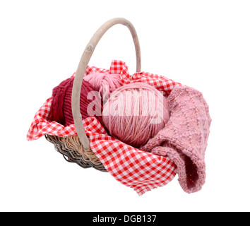 Pink and red balls of wool with patterned knitting in a basket, isolated on a white background Stock Photo