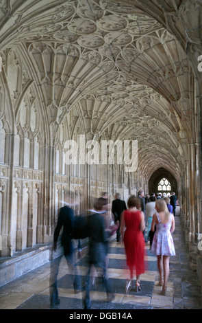 Woman in the Red Dress.  A wedding party moving through the Cloisters in Gloucester Cathedral, Gloucester, Glous, UK. Stock Photo