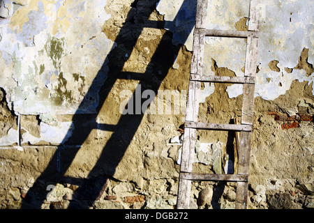 Color shot of a used wooden ladder with its shadow Stock Photo