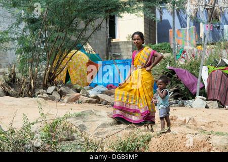 Lower caste Indian woman and child standing outside her bender / tent / shelter. Andhra Pradesh, India Stock Photo