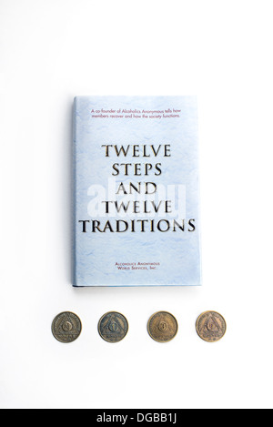 Alcoholics Anonymous AA Book 'The Twelve Steps and Twelve Traditions' with progress coins Stock Photo