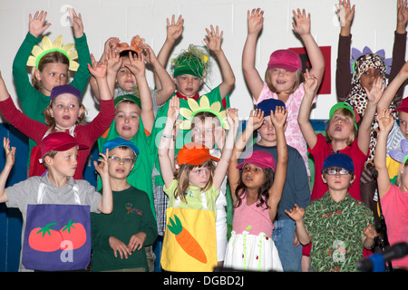 Students age 8  enthusiastically raising arms and singing in Spring Garden Musical. Horace Mann School St Paul Minnesota MN USA Stock Photo