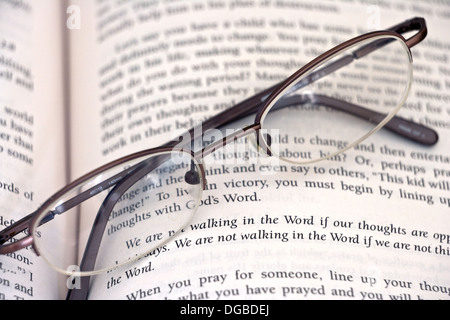 Pair of glasses laying on top of an open book. Stock Photo