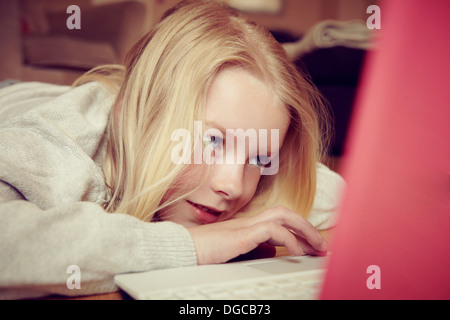 Young girl lying on floor using laptop Stock Photo