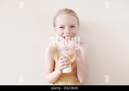 Young girl drinking milk from straw, portrait Stock Photo