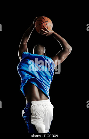 Male basketball player jumping with ball Stock Photo