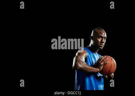 Studio portrait of basketball player holding ball Stock Photo