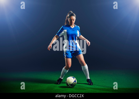 Female soccer player dribbling ball Stock Photo