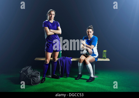 Portrait of two female soccer players on bench Stock Photo