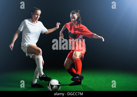 Two female soccer players tackling ball Stock Photo