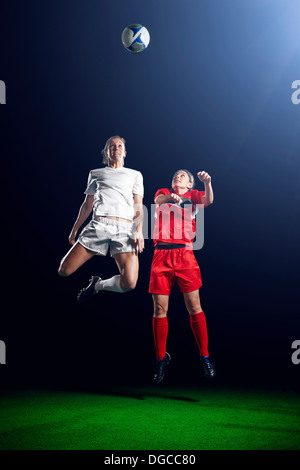 Two female soccer players heading ball Stock Photo