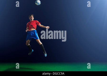 Young male soccer player heading ball Stock Photo