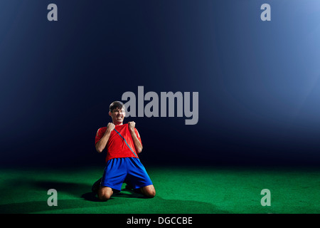 Male soccer player celebrating on knees Stock Photo