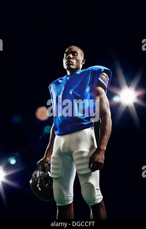 Portrait of american football player holding helmet Stock Photo
