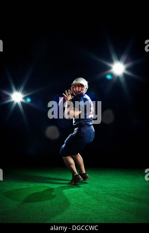 American footballer throwing ball Stock Photo