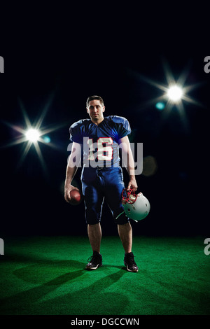 Portrait of american footballer holding helmet Stock Photo