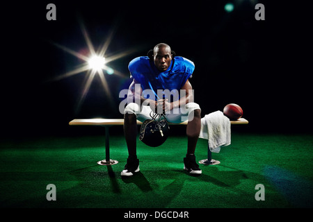 Portrait of american football player sitting on bench Stock Photo