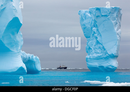 Adventure research ship Spirit of Enderby amongst ice bergs in the ice floe in the southern ocean Stock Photo