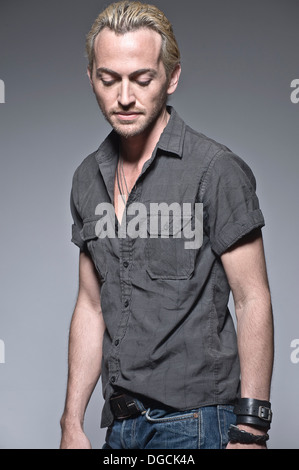 Young man looking down in studio Stock Photo