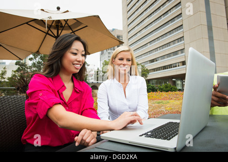 Young business colleagues looking at laptop Stock Photo