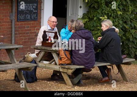 Bucklers Hard, New Forest, Hampshire, UK 18 October 2013. Making the most of the dry autumnal weather. People sitting at table waiting for food outside at the Master Builders House pub and hotel. Credit:  Carolyn Jenkins/Alamy Live News Stock Photo