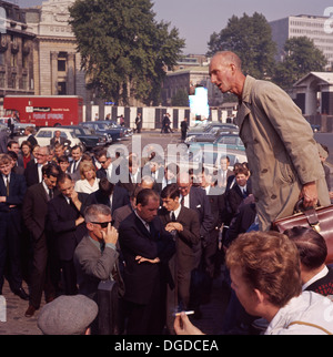 1960s, historical, summertime and a man wearing a raincoat and holding a leather briefcase, a soapbox speaker, addresses a lunchtime crowd outside at Tower Hill, London, EC3 England, UK. Tower Hill, along with speakers' corner in Hyde Park, were the two popular venues in London for open-air free speech making. Stock Photo