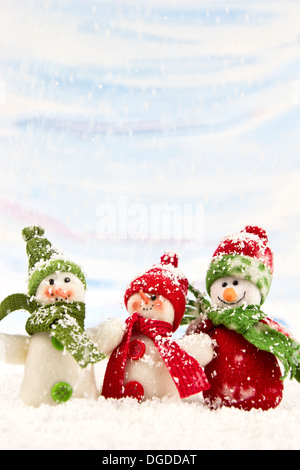 Three smiling snowmen friends in the snow - no name toy. Stock Photo