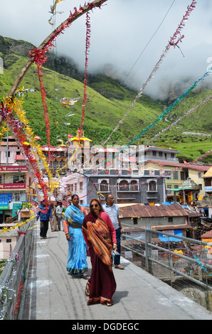 Pilgrims walking on a bridge to the Badrinath temple in the Himalayas, India Stock Photo
