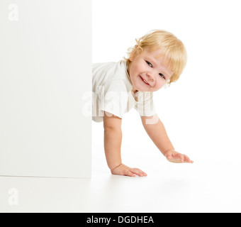Funny kid on all fours behind wall Stock Photo