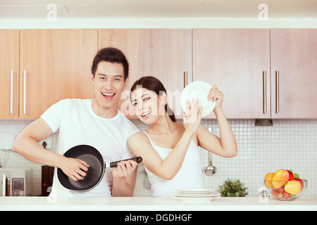 East Asian Young Couple Having Fun in Kitchen Stock Photo