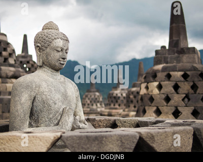 Ancient Buddha statue at Borobudur, the world's largest Buddhist monument in Java, Indonesia. Stock Photo