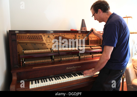 Old man tuning a Canadian-made grand upright piano Stock Photo