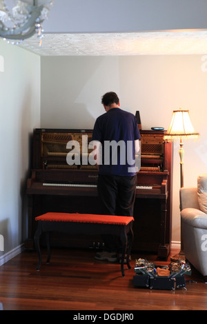 Old man tuning a Canadian-made grand upright piano Stock Photo