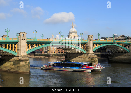 Thames Clipper river bus passes under Southwark Bridge London