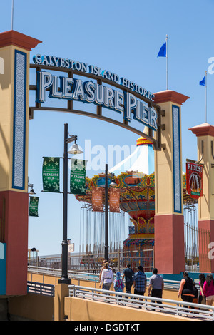 Tourists walking into Galveston Island Historic Pleasure Pier on sunny day Stock Photo
