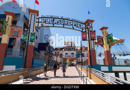 Tourists walking into Galveston Island Historic Pleasure Pier on sunny day Stock Photo