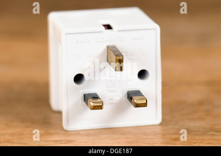 3 way plug adaptor 13 amp on wooden table top Stock Photo