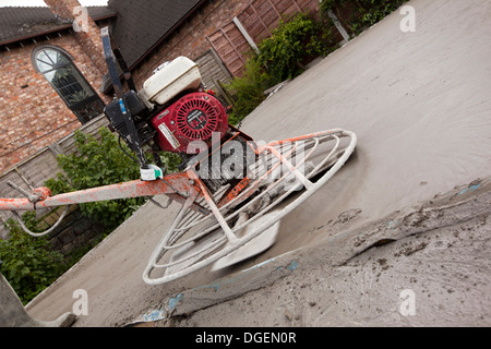 self building house, man using Honda power float mechanical trowel to float finish readymixed concrete floor slab flat Stock Photo