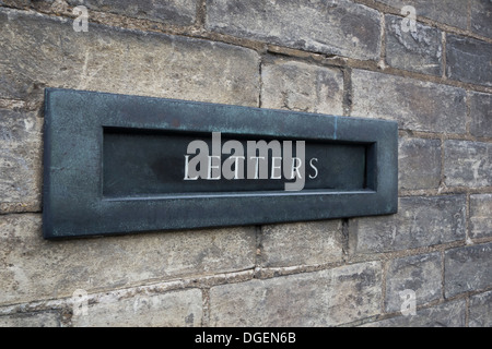 Post here: an old-style letterbox, with the word LETTERS displayed on it, in a brick wall. Stock Photo