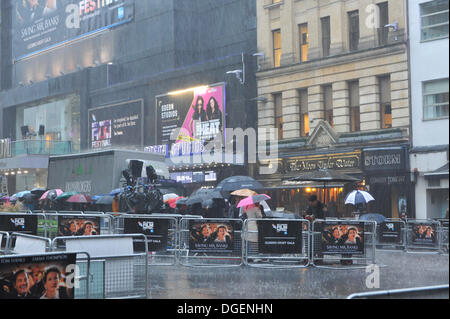 Leicester Square, London, UK. 20th October 2013. Film fans brave torrential rain in Leicester Square as they wait for tonight's closing gala of the British Film Festival, with the screening of Saving Mr Banks, starring Tom Hanks and Emma Thompson. Credit:  Matthew Chattle/Alamy Live News Stock Photo