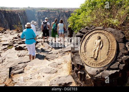Tourists at the Memorial plaque to David Livingstone at the top of the Victoria Falls, Livingstone Island, Zambia side, Africa Stock Photo