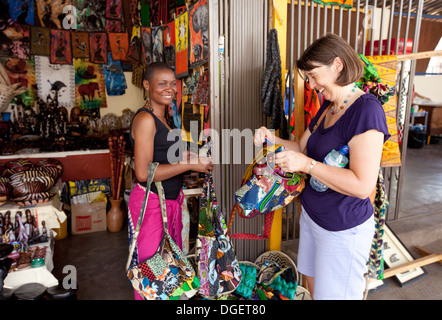 Tourist buying a bag from a local shopkeeper, Livingstone town centre, Zambia Africa Stock Photo