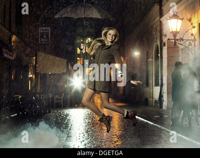 Fantastic photo of attractive lady jumping in heavy rain Stock Photo