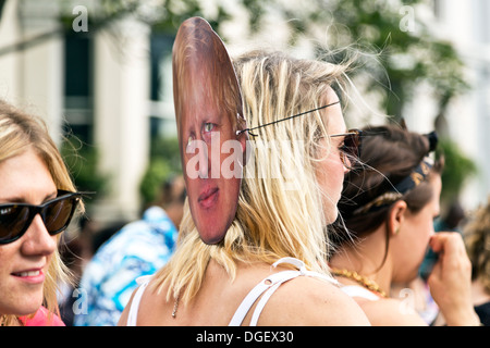 Young woman wearing a Boris Johnson face mask behind her head at the Notting Hill Carnival 2013, London, England Stock Photo