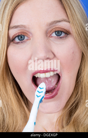 Model Released. Happy Young Woman Brushing Teeth Stock Photo