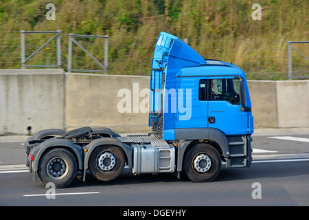 HGV lorry tractor unit & driver without trailer and with raised economy axle tyre saver feature activated driving along English UK M25 Motorway road Stock Photo