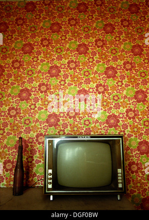 Old TV in front of a retro wallpaper. Stock Photo