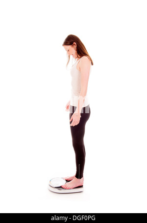 a girl on a weighing scale, celebrating her success of loosing weight Stock Photo