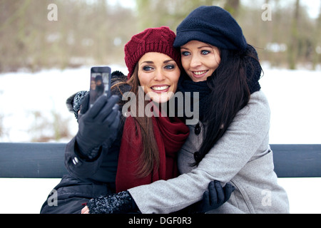 Two Friends Taking Picture of Themselves Using a Smartphone Stock Photo